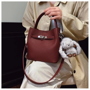 Détail du sac seau bordeaux en cuir grainé avec un porte-clés lapin en peluche doux