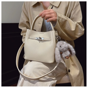 Détail du sac seau crème en cuir grainé avec fermoir argenté et breloque lapin