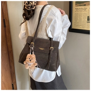 Détail du sac cabas rétro en cuir marron avec double boucle et petit ours en peluche