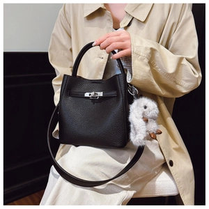 Détail d'un sac seau en cuir grainé noir avec fermoir métallique argenté et bijou de sac