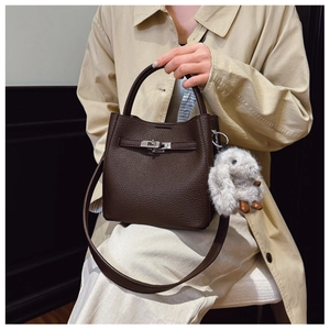 Vue détaillée du sac seau en cuir marron avec fermoir argenté et breloque lapin