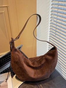 Minimalist dark brown suede hobo bag with top zipper and elegant knotted shoulder strap