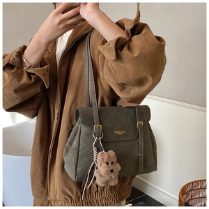 Détail du grand sac cabas vert olive avec logo, pompon et breloque en forme d'ours en peluche