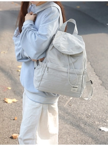 Détail d'un sac à dos en nylon gris avec fermeture à cordon et poche avant fonctionnelle