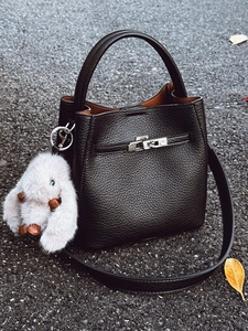 Sac seau minimaliste en cuir noir avec ferrures argentées et breloque lapin en peluche