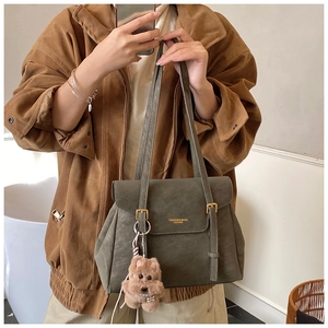Détail du sac cabas en cuir vert olive avec un charmant pendentif chien en peluche