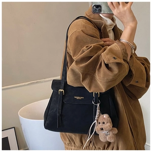 Détail du sac cabas noir mat avec boucle dorée et pendentif chiot en peluche