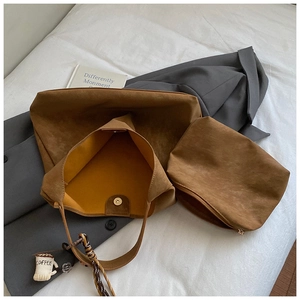 Detail view of brown suede tote bag set with yellow lining and silk scarf handle decor