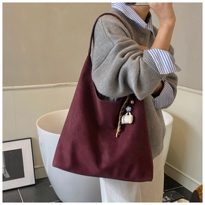 Detail of burgundy tote bag featuring a coffee cup charm and decorative silk scarf