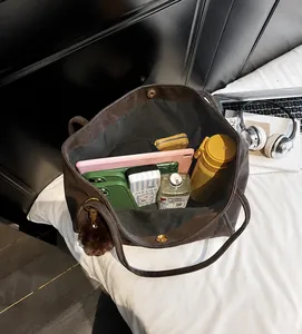 Top view of large capacity brown tote bag showing spacious interior with tablet and water bottle