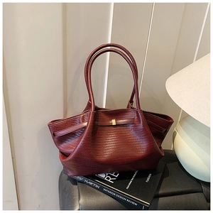 Detailed view of woven texture and gold buckle on vintage burgundy tote bag