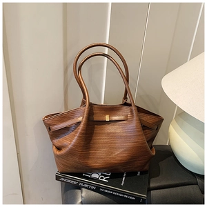 Detailed view of brown woven texture tote bag placed on an interior design book