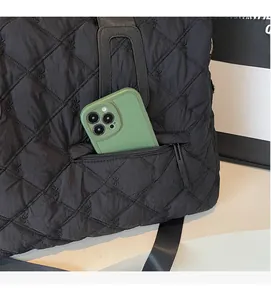 Détail du cabas matelassé noir avec broderie nœud et poche extérieure zippée pratique