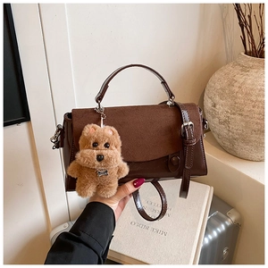 Detail der braunen Vintage-Tasche mit glänzendem Lackleder und mattem Wildleder-Design