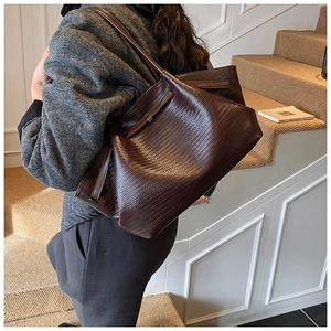 Close-up of large woven tote bag with premium leather texture and drawstring detail