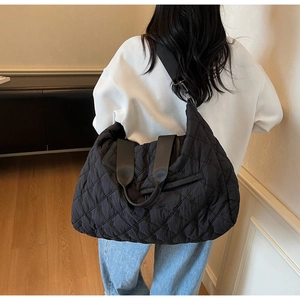 Détail du grand sac matelassé noir avec coutures en losange et bretelles souples rembourrées