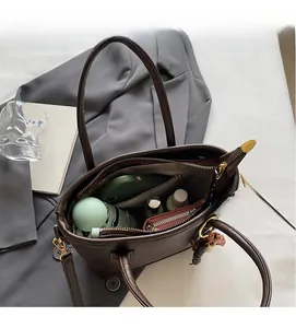 Spacious interior of dark brown leather tote bag showing storage for daily essentials