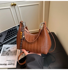 Detail of brown pleated shoulder bag showing textured faux leather and wooden bead charm