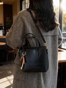 Retro black leather bucket bag with wooden bead charm and crossbody strap for women