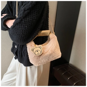Détail du sac à main en peluche rose avec pendentif ours et bandoulière en cuir souple
