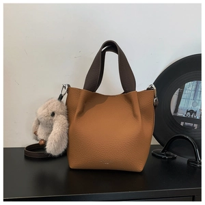 Dettaglio borsa a secchiello in pelle martellata con charm a forma di coniglio morbido