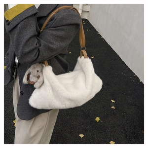 Dettaglio della borsa a tracolla in peluche bianca con ciondolo a coniglio e tracolla
