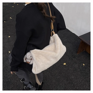 Vista posteriore della modella con borsa tote in peluche bianco sporco e tracolla marrone