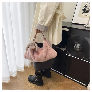 Borsa a tracolla in peluche rosa con ciondolo a coniglio grigio in scena moda