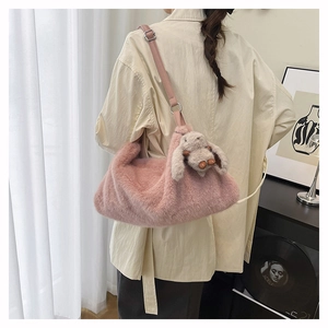 Dettaglio della borsa a tracolla rosa peluche con texture soffice e ciondolo a coniglio