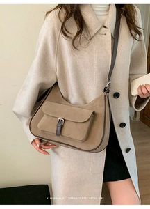Detail of retro khaki tote bag with front flap pocket and brown leather buckle strap