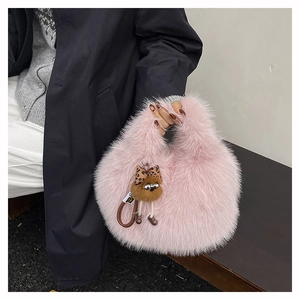 Dettaglio della borsa a secchiello in peluche rosa con ciondolo a fiocco leopardato