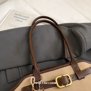Detail view of smooth top handle and metal buckle on retro office commuter handbag