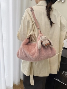 Borsa a tracolla in peluche rosa con ciondolo a coniglio vista sul retro di una modella