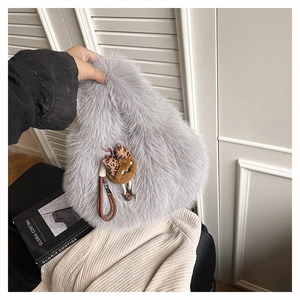 Dettaglio borsa in ecopelliccia grigio chiaro con fiocco leopardato e ciondolo pompon