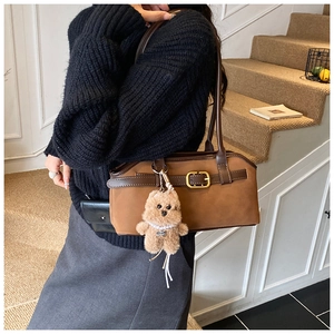 Detail der vintage mattbraunen Schultertasche mit Lederriemen und goldenen Metallschnallen