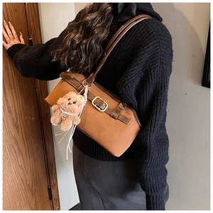Detailansicht der braunen Vintage-Schultertasche mit Teddy-Anhänger und goldener Schnalle