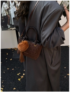 Détail du sac seau léopard marron avec pompon en peluche et breloques à franges