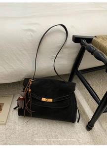 Detail der schwarzen matten Shopper-Tasche mit goldenem Drehverschluss und Teddybär