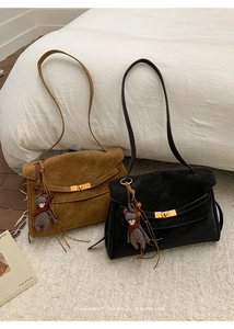 Detailansicht der Vintage-Tragetasche mit goldenem Drehverschluss und Bären-Anhänger