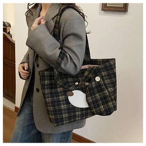 Detailansicht der Hundestickerei und des Retro-Knopfes auf der karierten Woll-Tote-Bag