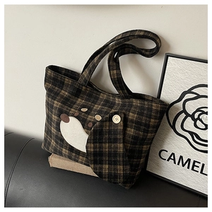 Detail von niedlichem Hunde-Stickerei-Patch und Karostoff an einer Vintage-Tasche