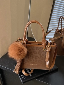 Sac seau chic en cuir marron avec empiècement léopard et breloque pompon en fausse fourrure