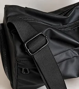Close-up of adjustable woven shoulder strap with black metal buckle on a travel bag