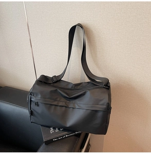 Detail of minimalist black crossbody cylinder bag with adjustable strap on leather