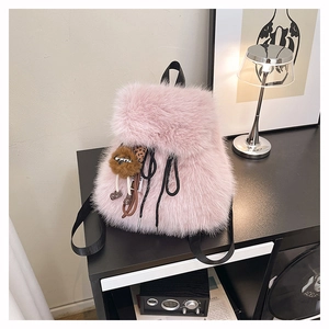 Dettaglio dello zaino in peluche rosa con pelliccia lunga e ciondolo a leoncino