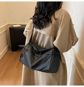 Fashionable black crossbody bag on model showing large capacity and casual style