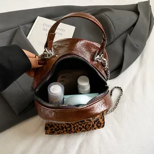 Vue intérieure montrant le rangement du téléphone et cosmétiques dans le sac léopard
