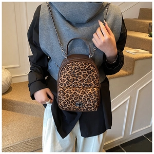 Vue détaillée du sac à dos matelassé léopard avec bandoulière chaîne et fermoir tournant
