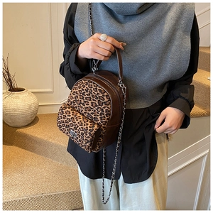Détail du mini sac à dos léopard avec texture matelassée et bandoulière en chaîne
