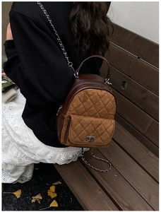 Vue arrière d'un mannequin portant le mini sac à dos matelassé marron à chaîne dorée